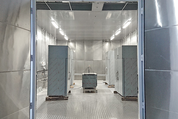 Вид климатической камеры с открытыми воротами и загруженным для испытаний оборудованием Фото-Вид климатической камеры с открытыми воротами и загруженным для испытаний оборудованием